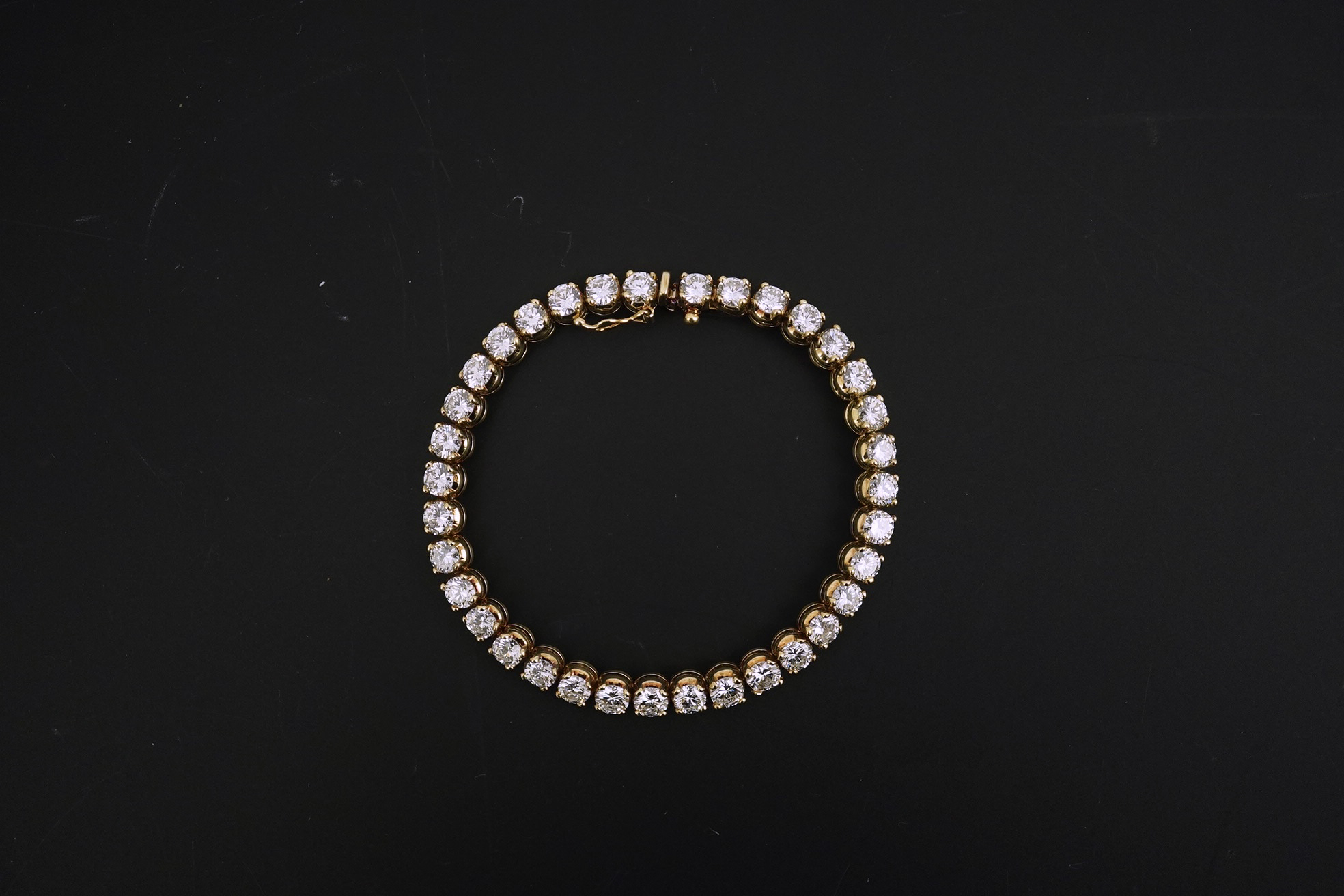 A modern 14k gold and thirty five stone round brilliant cut diamond set tennis bracelet